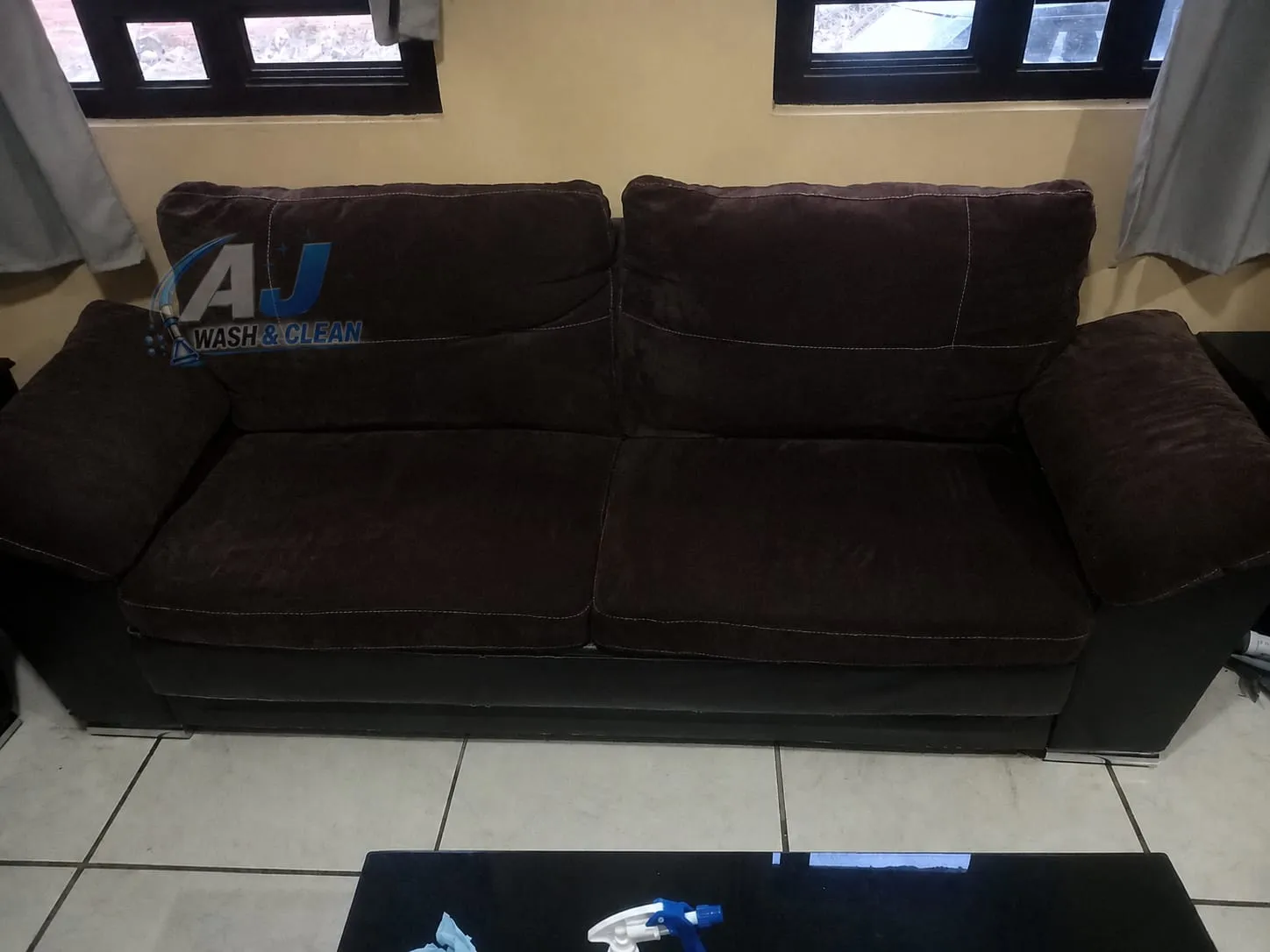 Sofá de tela oscura con tonos uniformes después de la limpieza